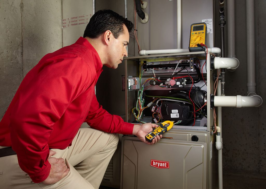 Heating and air conditioning technician servicing an indoor furnace in Draper, UT