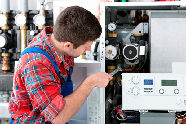 HVAC technician inspecting an indoor heating system in Draper, UT