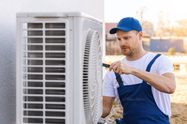 HVAC technician servicing an outdoor air conditioning unit in Draper