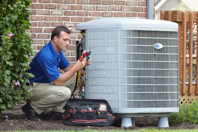 design-air-heating-and-air-conditioning-decatur-il-05 – Copy HVAC technician inspecting an outdoor air conditioning unit in Draper, UT