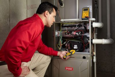 furnace repair Heating and air conditioning technician servicing an indoor furnace in Draper, UT